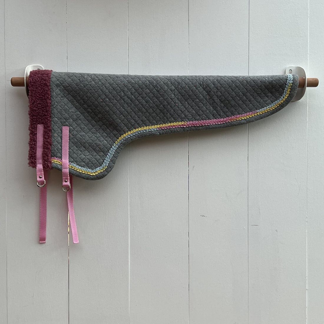 dekentje lang grijs afwerkt met een bandje met verschillende kleuren