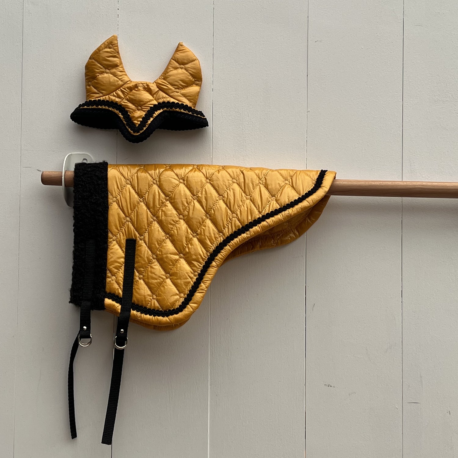 Dekentje kort geel glimmende stof met zwart bandje + oornetje