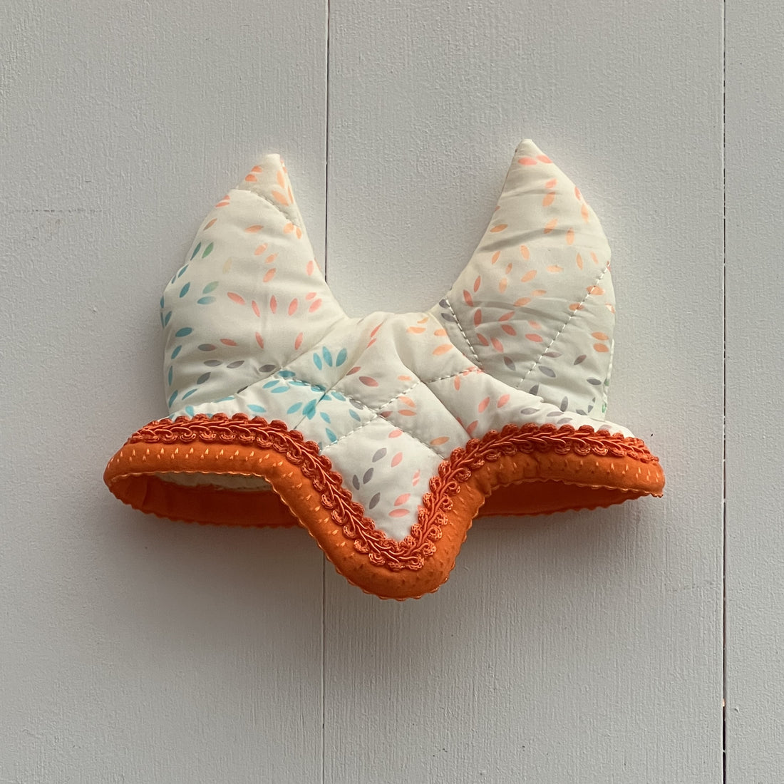 Oornetje creme met gekleurde figuurtjes bies oranje en oranje bandje