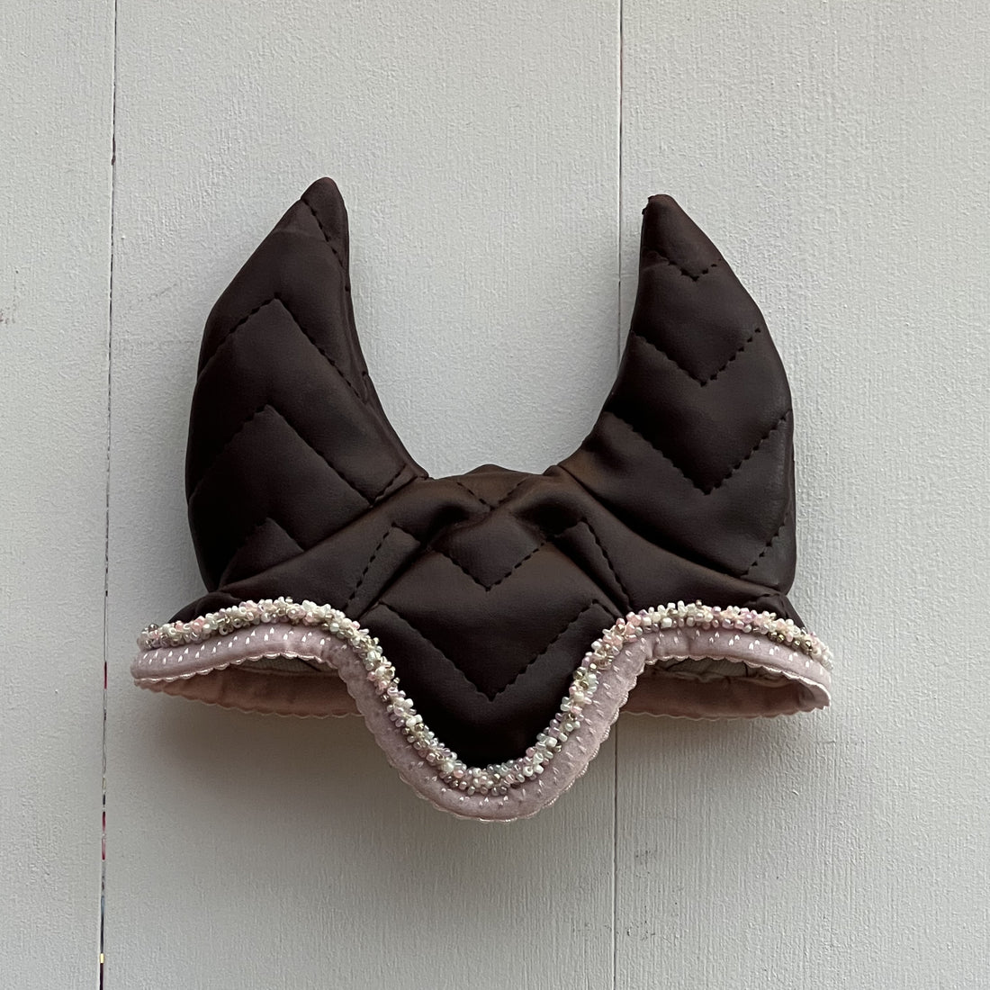 Oornetje bruin leerachtige stof met roze bies met gekleurde kraaltjes