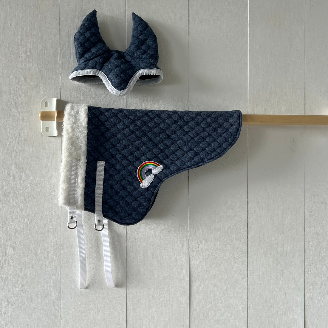 Dekentje kort rood gebreide stof met bolletjes motief met applicatie van een regenboog + oornetje